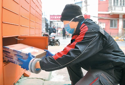 今年2月份，防疫期間，在北京市海淀區中關村街道科育社區內，快遞員將快遞放入智能快遞柜。 　　新華社記者 任 超 攝